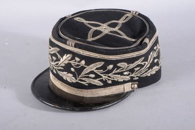 un chapeau noir orné de broderies dorées sur fond blanc