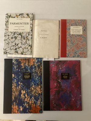 Quatre livres sont alignés sur une table blanche