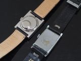 two watches that are sitting on a black table