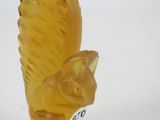 a yellow glass figurine of a cat with a tail