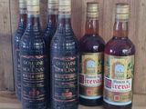 plusieurs bouteilles de vin sont alignées sur une étagère en bois