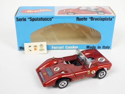 une petite voiture rouge devant une boîte