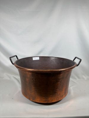 une vieille casserole en cuivre avec des poignées, sur fond blanc