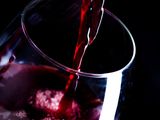 un verre de vin rouge que l'on verse dans un verre à vin