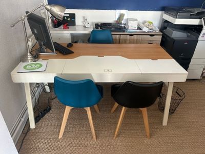 a desk with two chairs and a computer on it