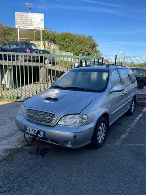 une voiture argentée garée sur un parking près d'une clôture