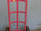 un diable rose posé devant la porte d'un garage