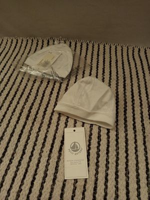 un chapeau posé sur un lit, avec une étiquette
