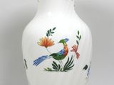 un vase blanc orné d'un oiseau et de fleurs