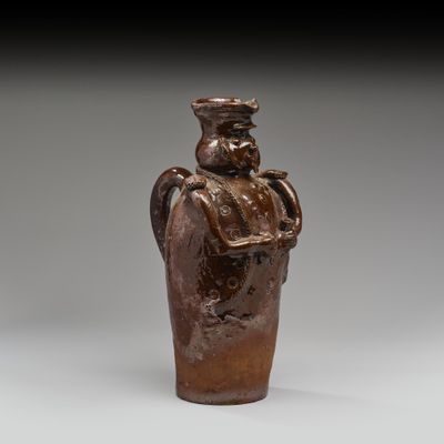 une image représentant un vase marron sur lequel figure un homme