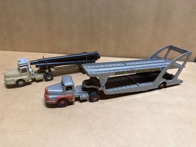trois camions miniatures et un semi-remorque posés sur une table
