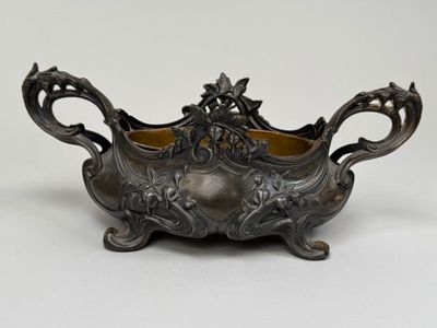 an antique silverplated bowl with floral decoration on a stand