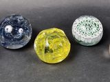 six different colored glass marbles sitting on top of a black surface