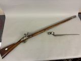 un vieux fusil avec une crosse en bois et un couteau posés sur une table