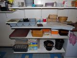 a shelf with dishes and pans on it in a kitchen