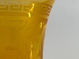 a yellow vase sitting on a table with a white background