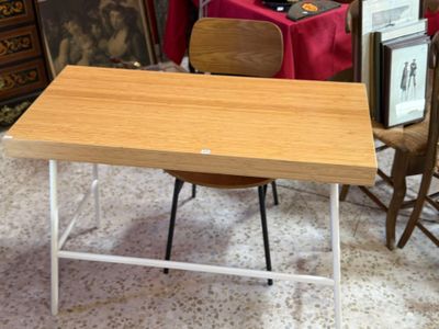 une table avec une chaise et un tableau accroché au mur