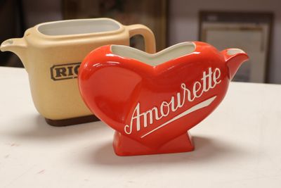 a red heart shaped teapot next to a yellow teapot