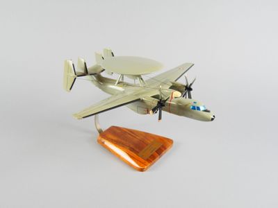 une petite maquette d'un petit avion posée sur un socle en bois
