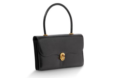 un sac à main en cuir noir muni d'un fermoir doré sur la poignée