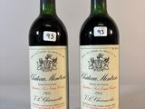 deux bouteilles de vin posées sur une table l'une à côté de l'autre