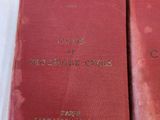 two red books sitting on top of each other on a white surface