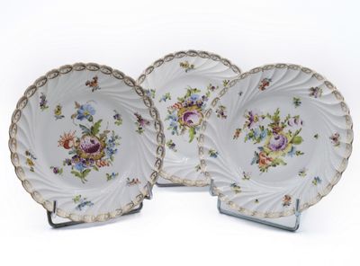 two plates with flowers on them on a white surface