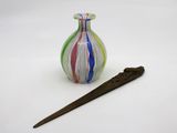 un petit vase en verre avec un bâtonnet en bois à côté