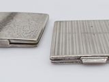 deux étuis à cigarettes en argent posés l'un à côté de l'autre sur une surface blanche