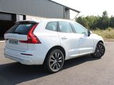 the rear end of a white volvo suv parked in front of a building