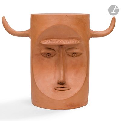 un vase en argile orné d'un visage et de cornes