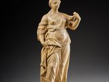 a carved statue of a woman holding a bird