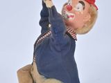 a small figurine of a clown holding a tennis racquet