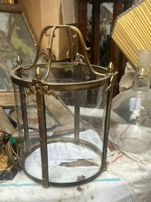 une lanterne en verre posée sur une table, à côté d'autres objets