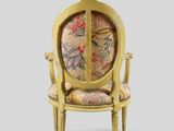 a gold chair with a floral upholstered back