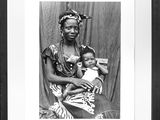 an old black and white photo of a woman holding a baby