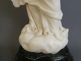 statue en marbre représentant une femme tenant un bébé dans ses bras, posée sur un socle en marbre