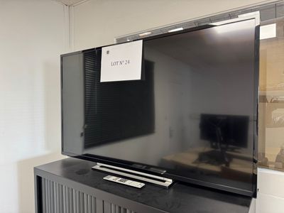 une télévision à écran plat posée sur un meuble TV noir