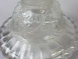 a clear glass vase with a white base sitting on a table