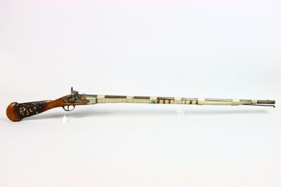 un vieux fusil avec un canon en bois et une poignée en bois