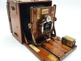 un vieil appareil photo posé sur un support en bois