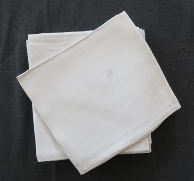 Deux serviettes blanches sont empilées l'une sur l'autre sur une table noire.