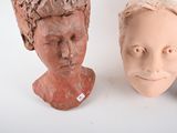 two clay heads sitting next to each other on a table