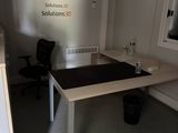 a desk with a chair and a window in the room