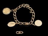 a gold bracelet with coins and charms on a black background