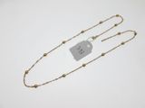 a gold chain necklace with a tag on it