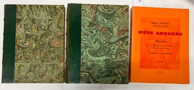 Trois livres sont posés sur une surface blanche ; l'un d'eux a une couverture verte et orange.