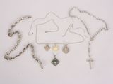 a lot of necklaces and a cross on a white surface