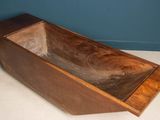 a wooden bathtub with a wooden base on the floor