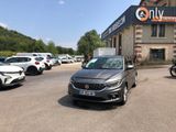 de nombreuses voitures garées devant un immeuble sur lequel est accrochée une pancarte
